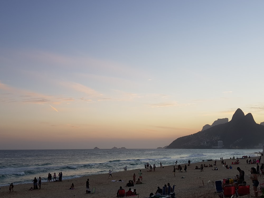 people walking and sitting on seashore