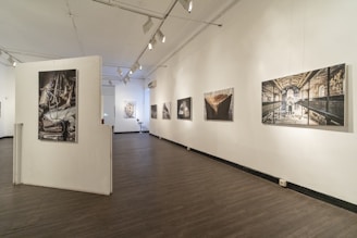 Bright, welcoming gallery interior with contemporary artworks displayed on rustic walls.