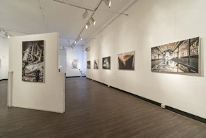 Wide shot of the gallery interior showcasing paintings with dynamic lighting effects.