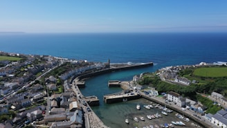 An aerial view of a coastal town with boats docked along the harbor.