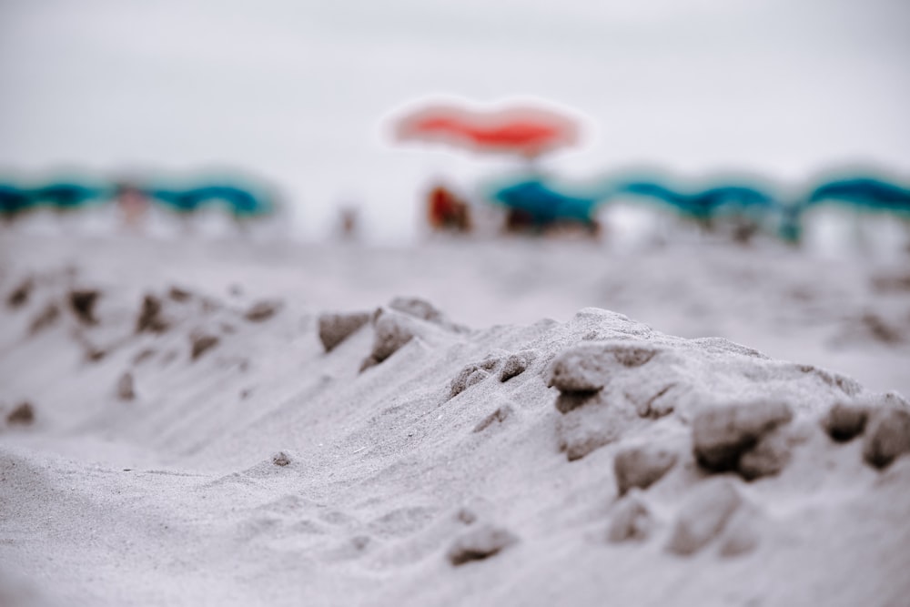 a sandy beach with a red umbrella in the background