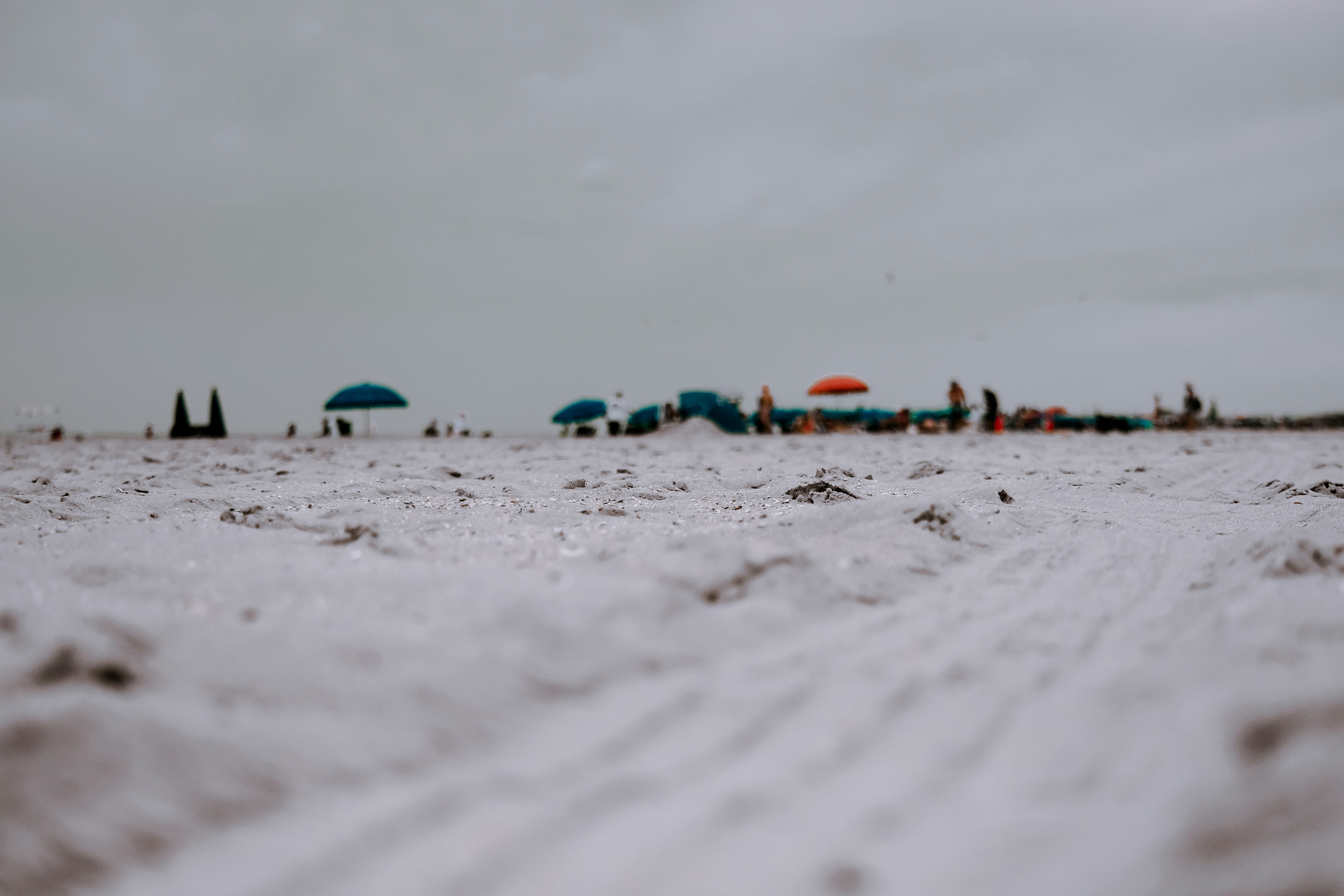 low-angle photo of white sand beach with view of beach umbrellas