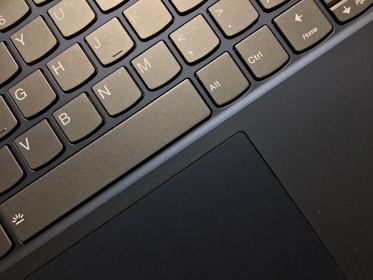 Close-up of hands using keyboard shortcuts on a laptop.