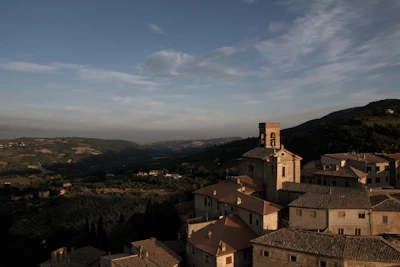A panoramic view of a charming village perched on a hillside under a clear blue sky.