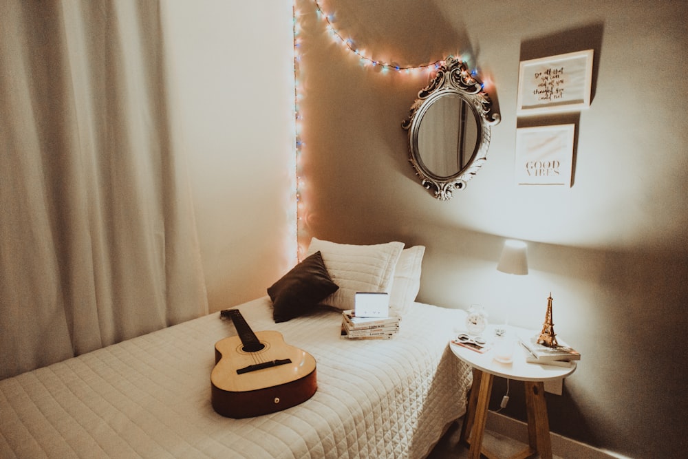 beige guitar on white bedspread