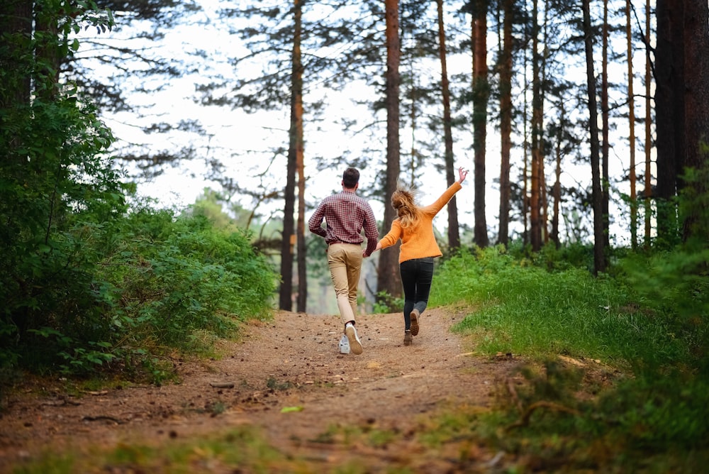man and woman walking on forest