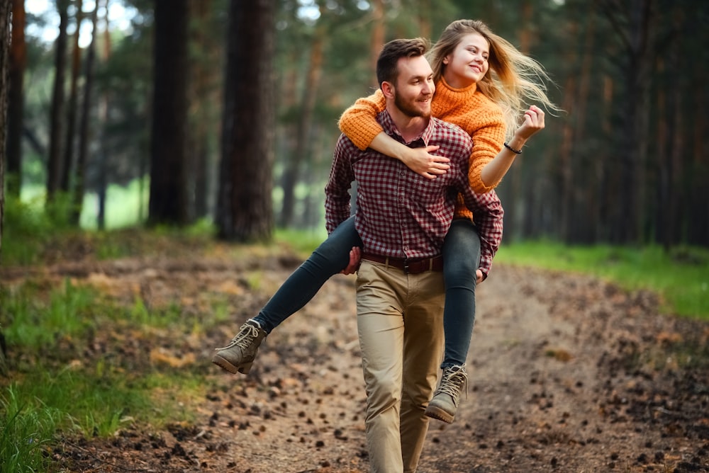 shallow focus photo of man carrying woman