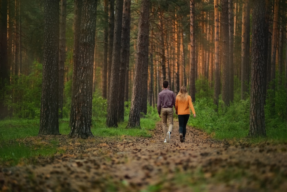 man and woman walking on walkway with dried leaves