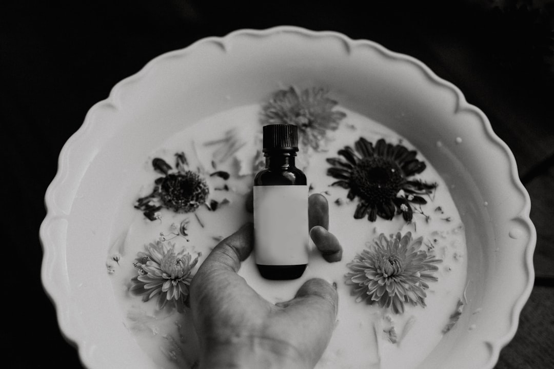 grayscale photo of person holding bottle,
