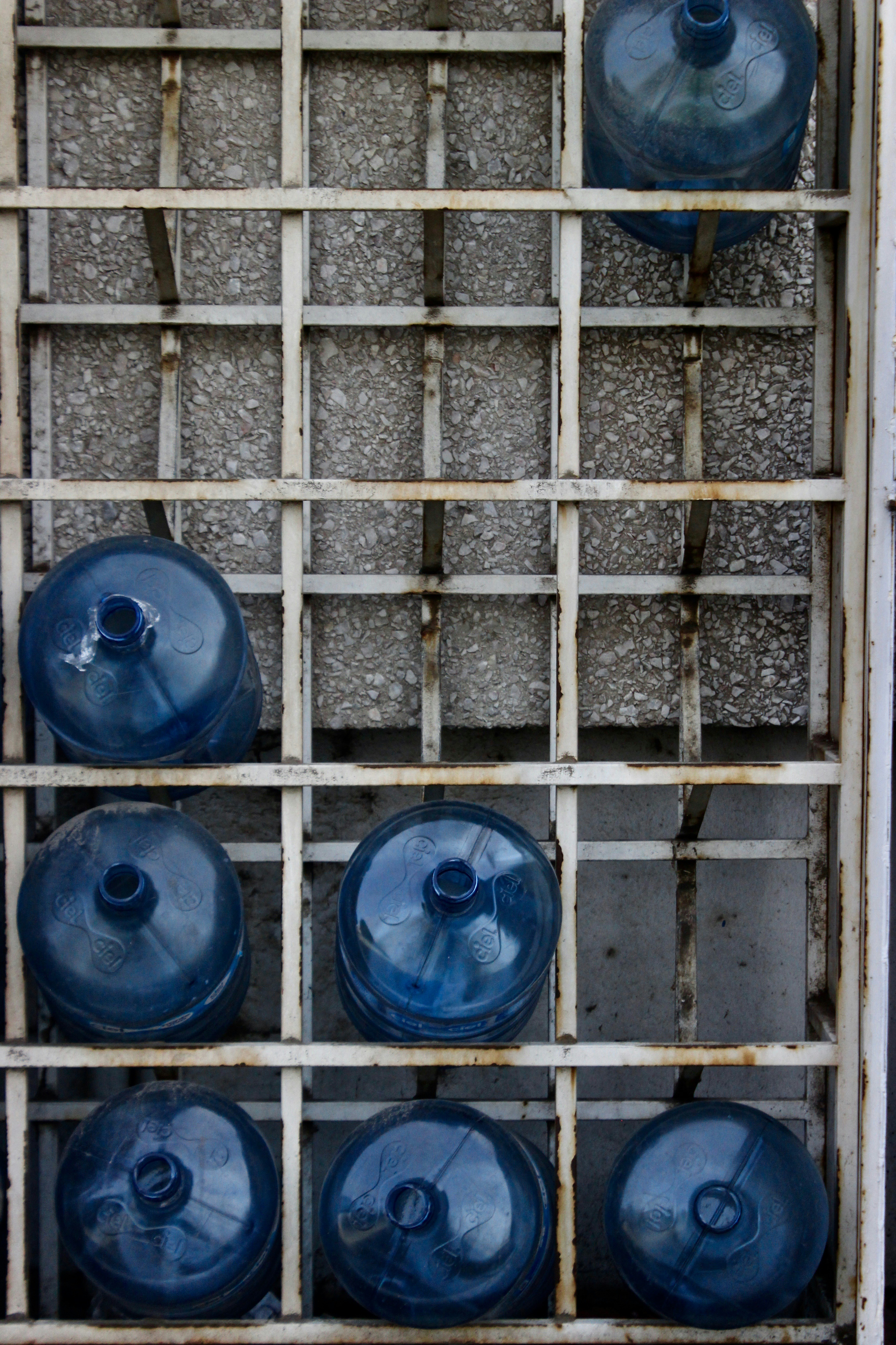seven blue plastic carboys