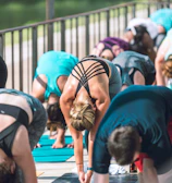 Outdoor yoga class at sunrise with participants stretching on mats.