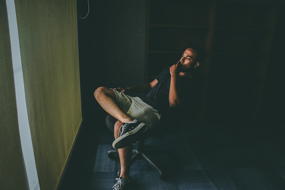 man in black shirt sitting on chair