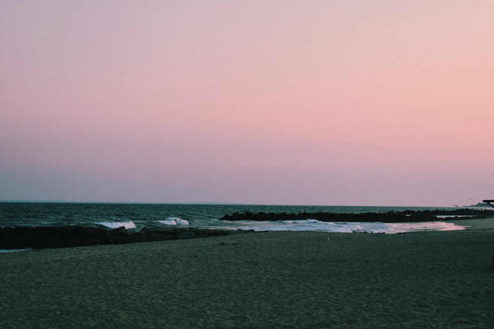 a person standing on a beach next to the ocean