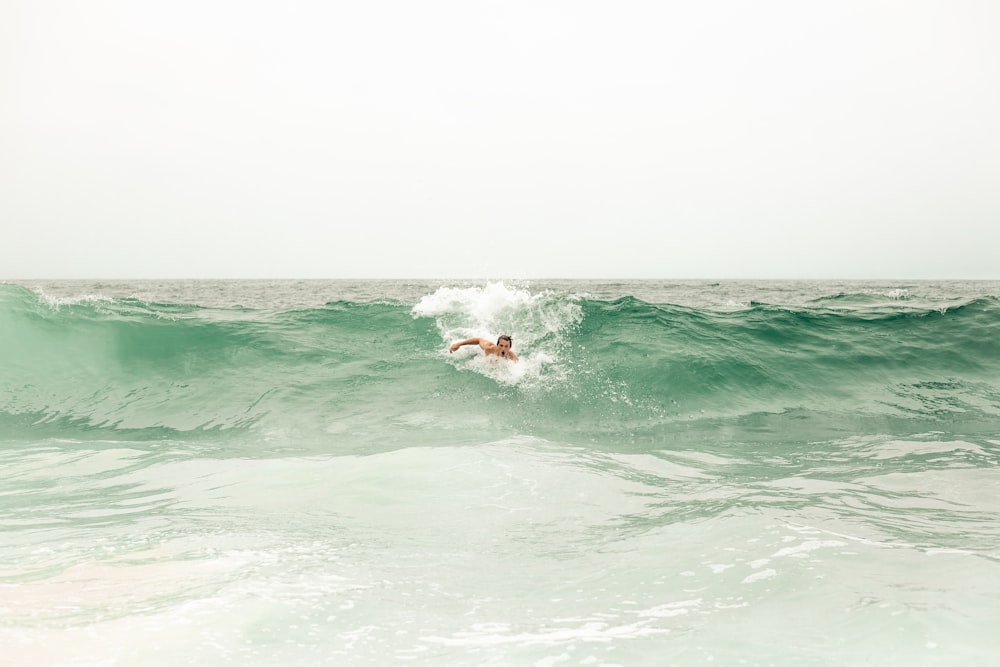 a man riding a wave on top of a surfboard