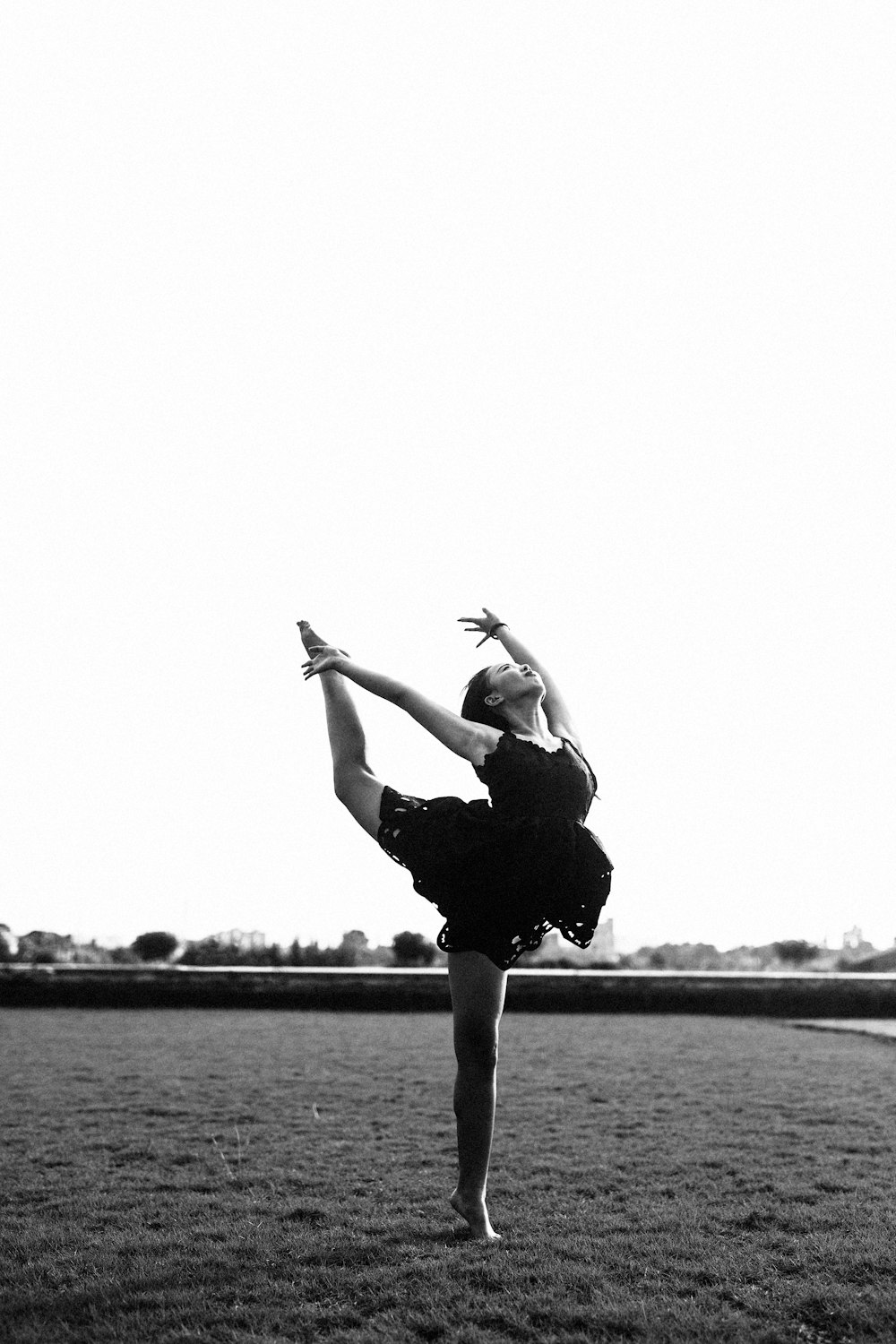 women bending in a field gray-scale photography