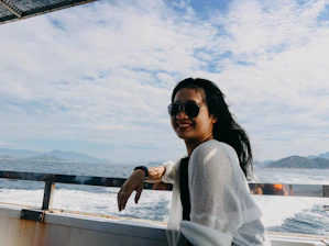 Close-up of a local skipper smiling warmly aboard a luxury boat, with the sun setting over the sea behind him.