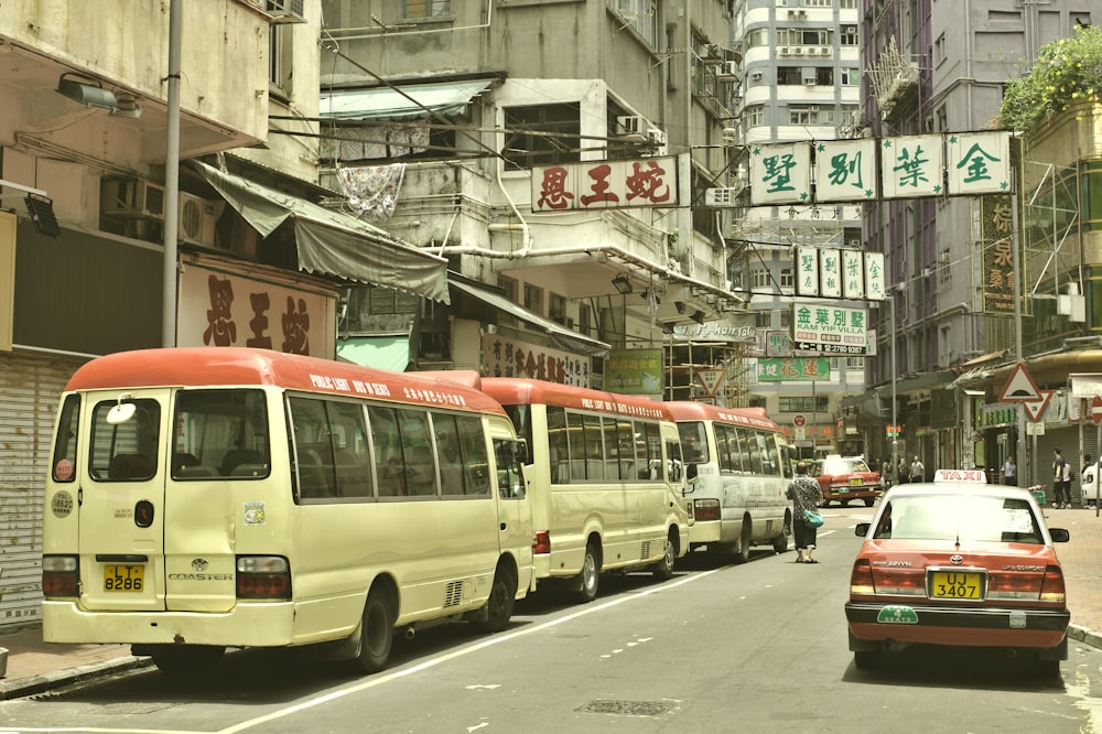 흰색과 빨간색 버스가 건물 근처에 주차되어 있습니다.