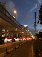 Tow truck assisting a car on a busy city street at dusk.