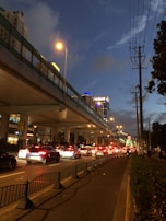 Installation of lighting and signaling systems on a busy city street at dusk.