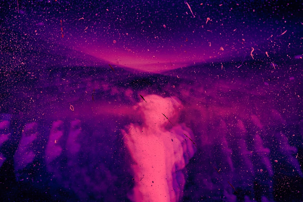 une photo violette et noire d’une personne dans l’obscurité