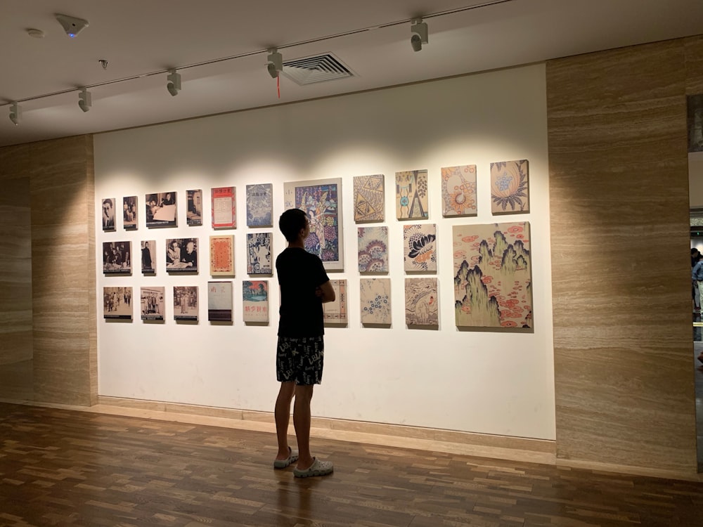 man standing in front of paintings