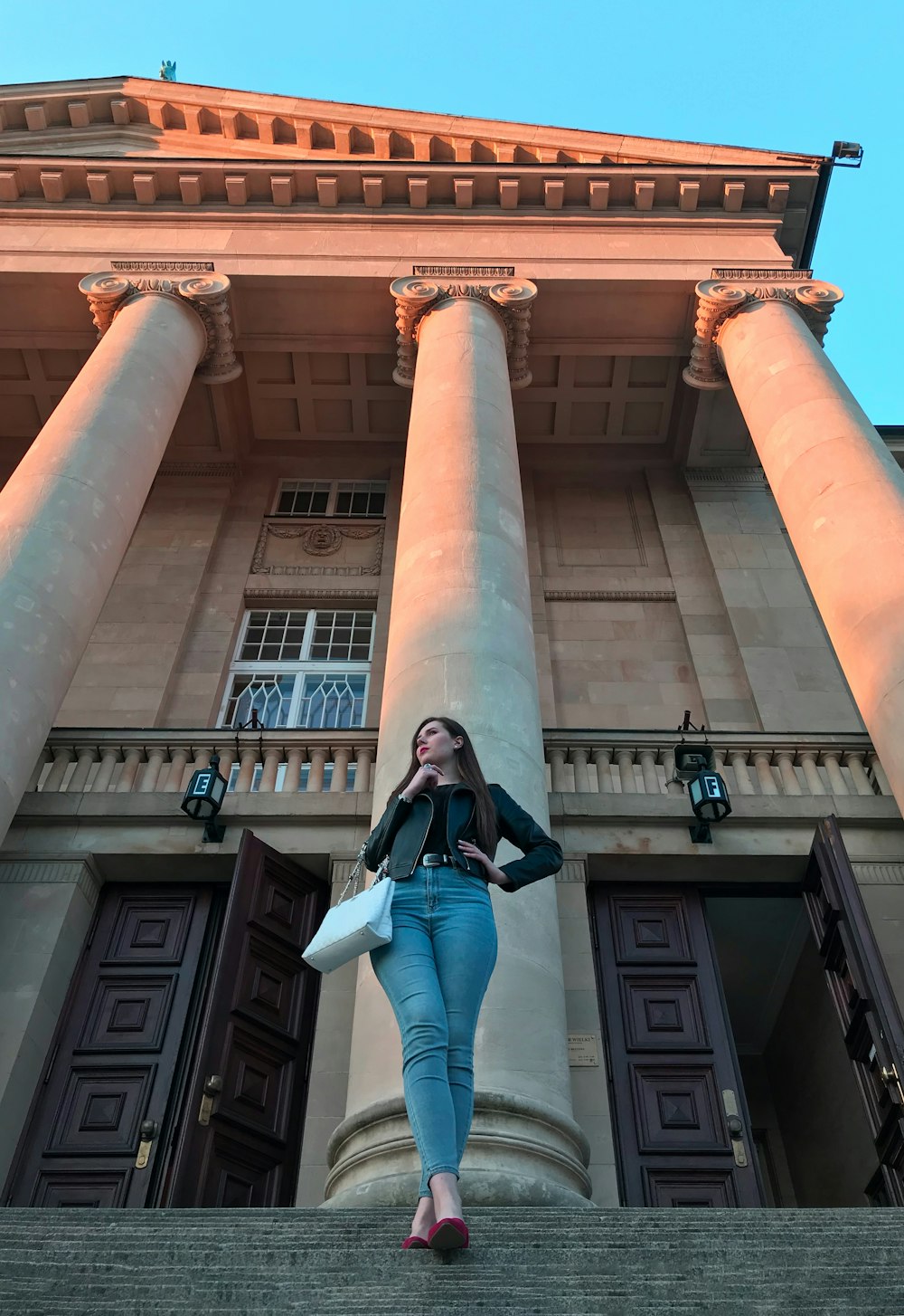 a woman standing on the steps of a building