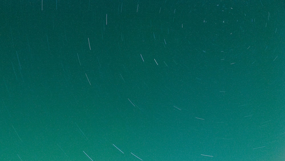 a group of people standing on top of a hill under a star filled sky