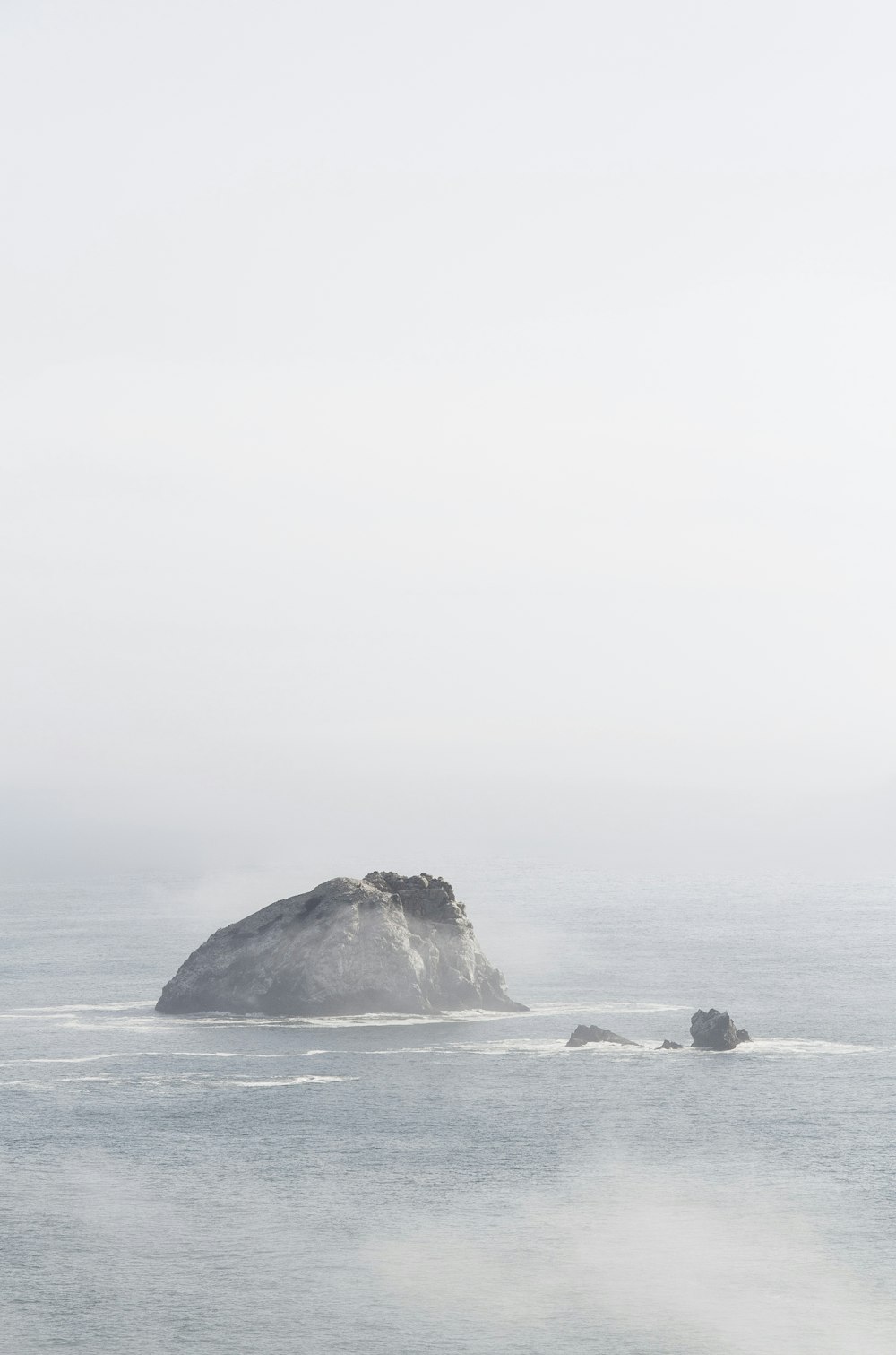 a large rock in the middle of a body of water