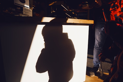 A shadow teacher supporting a child during a classroom activity with gentle encouragement