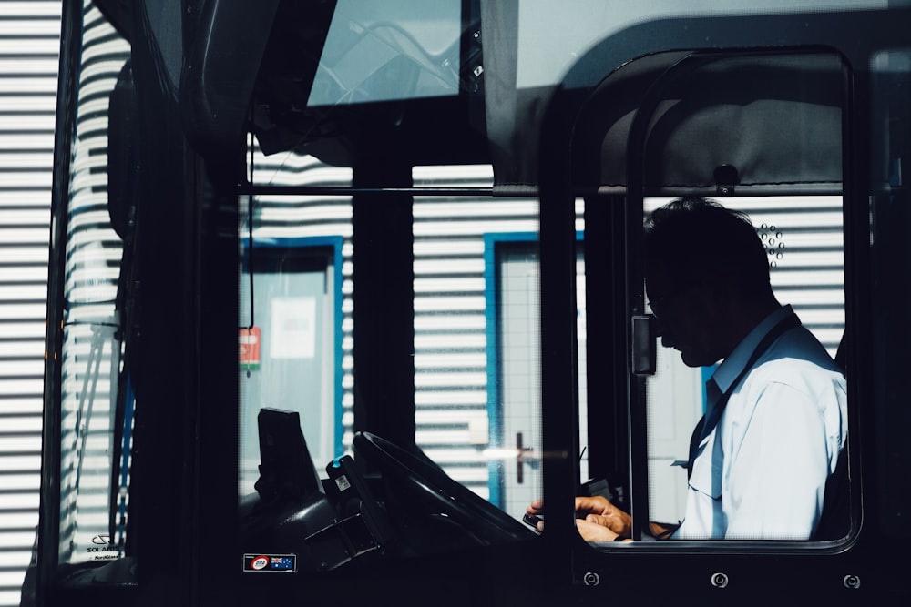 silhouette photography of man driving bus