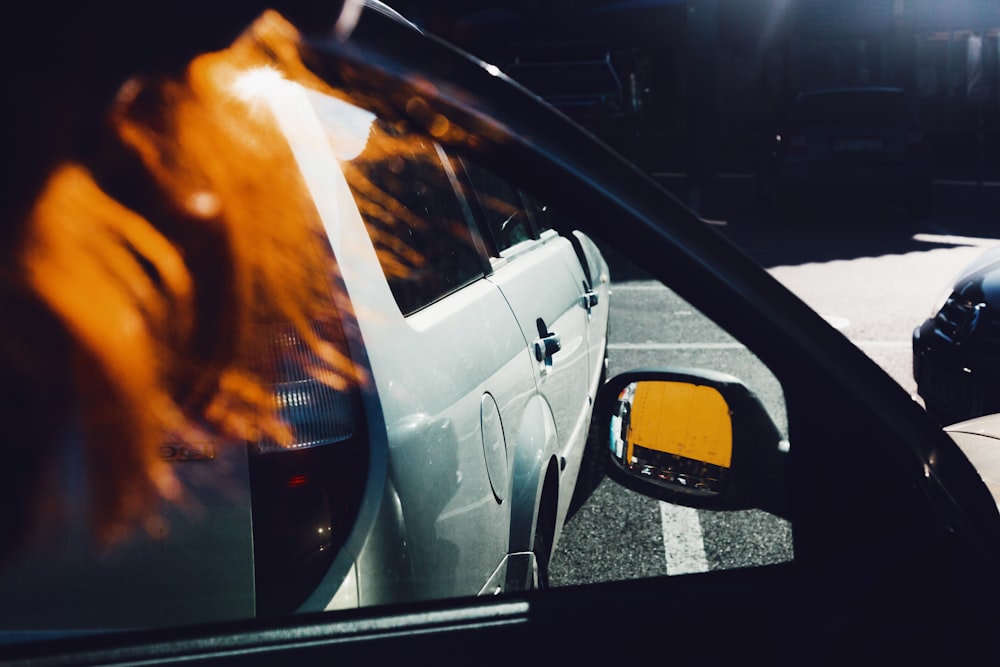 a side view mirror of a car parked in a parking lot