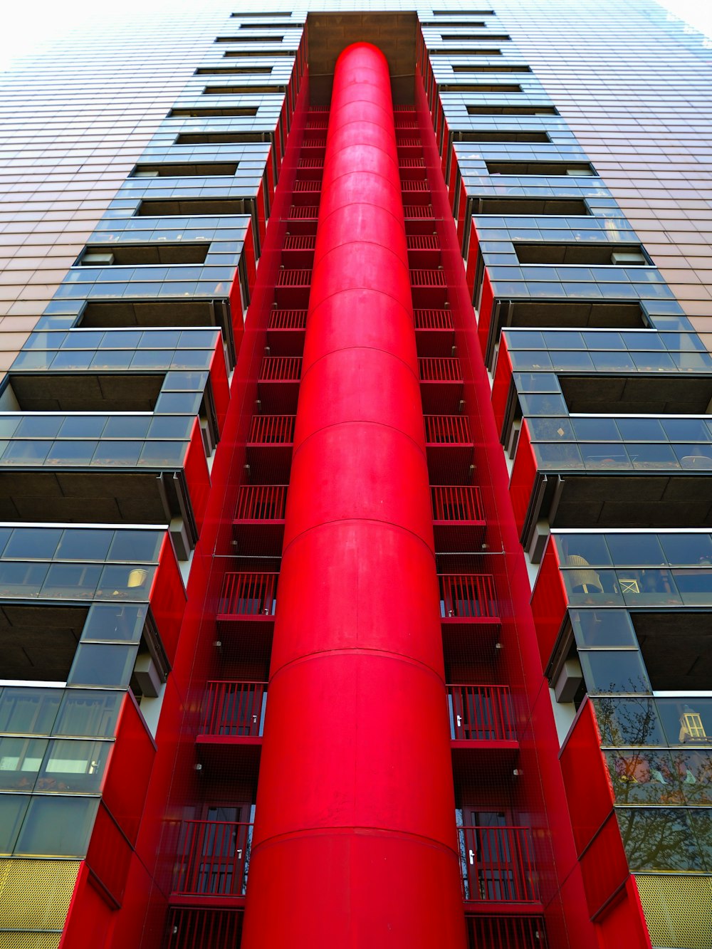 a tall red building with balconies on the top