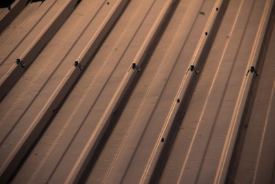 Neatly arranged bundles of metal roofing panels reflecting sunlight.