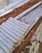 Multiple sheets of corrugated metal, some showing signs of rust and age, are scattered on the ground. Dried leaves and small debris are visible on top of the metal surfaces.