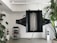 A modern living space featuring a large, abstract black sound system hanging from the ceiling. On the floor, there are two white standing speakers on either side, and a metal shelving unit housing electronic equipment. Potted plants with lush green leaves add a touch of nature to the minimalistic decor.