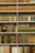 A serene bookshelf filled with various books, illuminated by soft natural light.