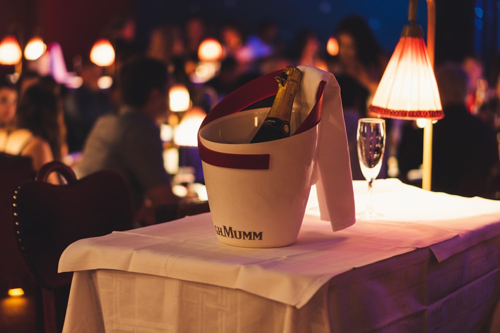 a table topped with a bucket filled with bottles of wine