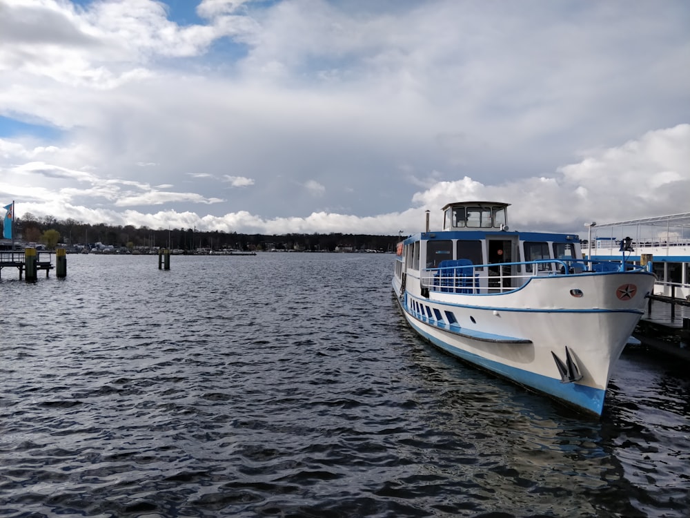 white and blue boat on dock