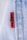 A close-up view of a denim fabric with prominent stitching details. A small red tag with black text is visible, partially showing a brand name. The fabric texture and stitching are clearly defined, illustrating the quality and craftsmanship of the material.