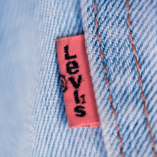 Macro photo of a red Levi's tab stitched to the back pocket of blue jeans