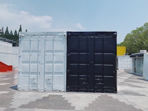 two white and black cargo containers near trees