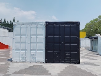 two white and black cargo containers near trees