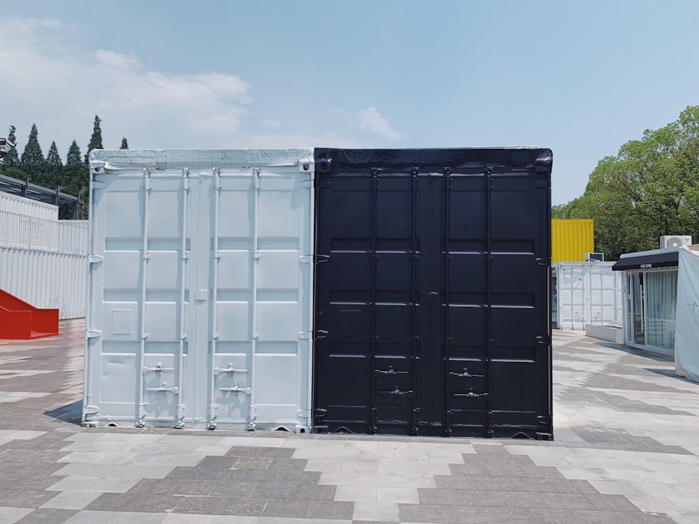 two white and black cargo containers near trees