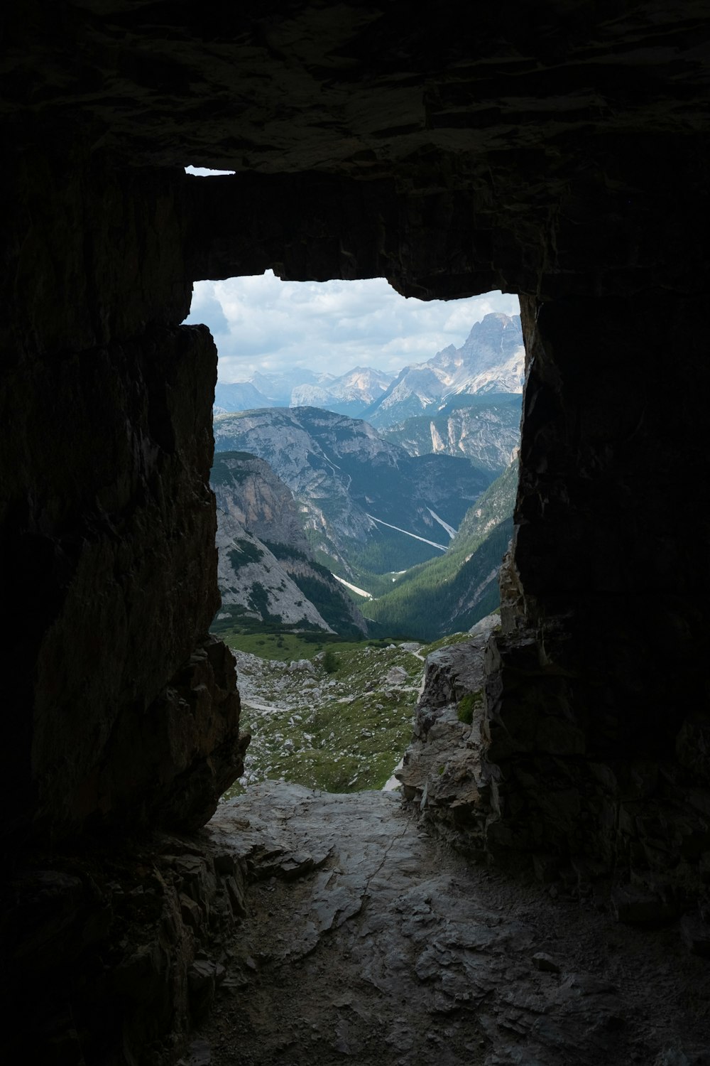 uma vista de uma cordilheira através de uma caverna