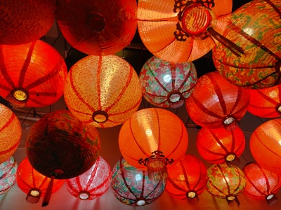 Close-up of colorful paper lanterns hanging from the ceiling, casting a warm glow.