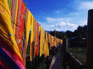A vibrant mountain village with locals weaving traditional textiles outdoors.