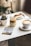 a table topped with a cup of coffee and a plate of food