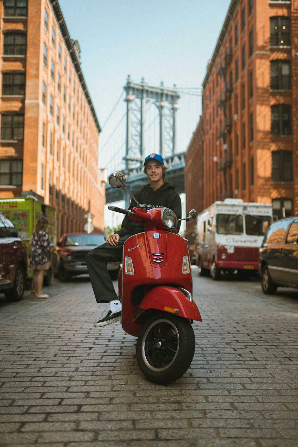 man sitting on red motor scooter