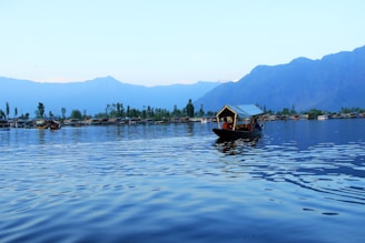 people riding boat on body of water near island
