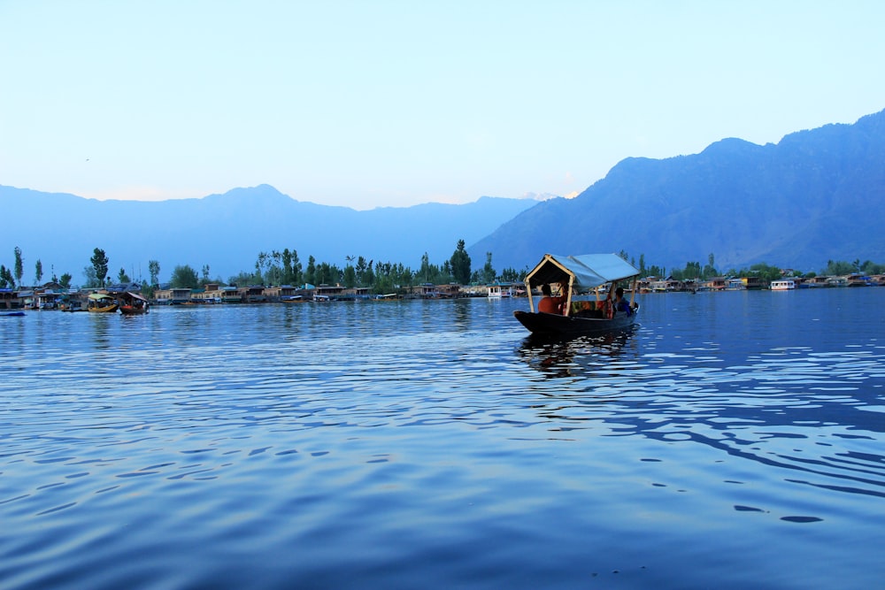 people riding boat on body of water near island